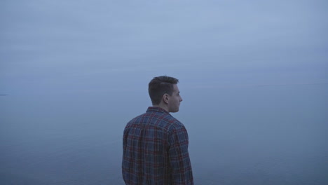 Caucasian-man-standing-next-to-a-foggy-lake