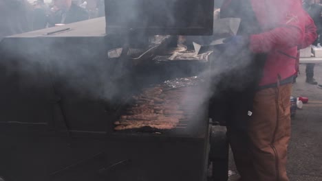 Slow-motion-clip-of-a-man-barbecuing-meat-at-a-Mardi-Gras-street-celebration
