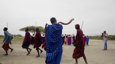 Hombres-De-La-Tribu-Massai-Realizando-Danza-De-Bienvenida-Para-Los-Turistas,-Parque-Nacional-Del-Serengeti,-Tanzania