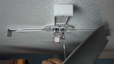 Installing-a-brand-new-LED-light-mount-for-a-light-upgrade-and-hooking-the-safety-line-to-hang-and-start-twisting-the-wires-together