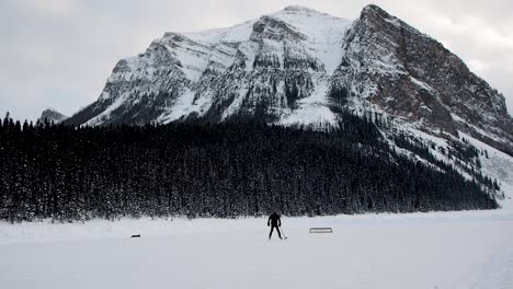 Playing-hockey-on-frozen-lake-with-mountains-in-background