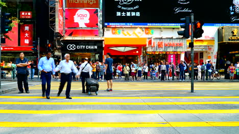 Hongkong---Zeitrafferschwenk-über-Einen-Belebten-Fußgänger-Zebrastreifen-In-Der-Innenstadt-Von-Hongkong-Mit-Vielen-Vorbeifahrenden-Autos-Und-Doppeldeckerbussen,-Tageslichtsituation-Ohne-Bewölkung