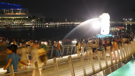 Singapore---Circa-People-walking-on-crowded-bridge-by-Merlion-Fountain-in-Singapore-at-night