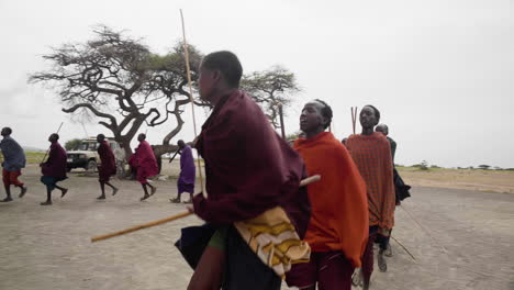 Hombres-De-La-Tribu-Massai-Realizando-Danza-De-Bienvenida-Para-Los-Turistas,-Parque-Nacional-Del-Serengeti,-Tanzania