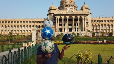 Un-Artista-Que-Realiza-Trucos-Con-Balones-De-Fútbol-Frente-Al-Edificio-Vidhana-Soudha-En-Bengaluru,-Karnataka,-India,-Durante-La-Madrugada