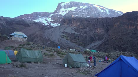 Leve-Inclinación-Hacia-Arriba-Desde-Un-Campamento-De-Caminata-Kilimanjaro-Con-Carpas-Que-Revelan-La-Cima-Del-Monte-Kilimanjaro
