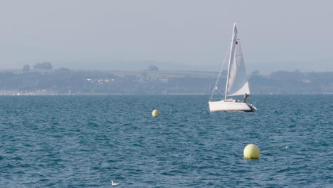 a-sailboat-drives-by-on-a-lake