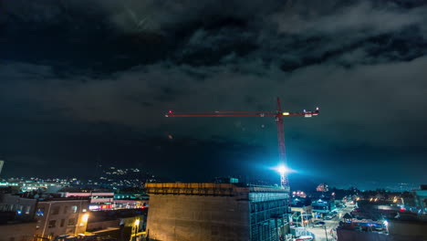 Night-time-time-lapse-of-crane-over-developing-downtown