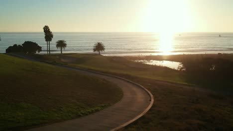 Luftaufnahme-Des-Golfplatzes-Mit-Meerblick-Bei-Sonnenuntergang