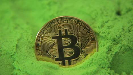 Moneda-De-Oro-Bitcoin-En-Un-Mar-De-Verde-Con-Destellos-De-Luz-Y-Reflejos