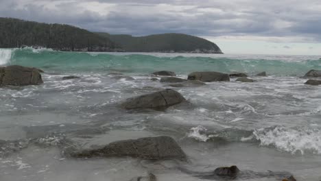 Handgehaltene-Zeitlupenaufnahme-Einer-Welle,-Die-über-Felsen-Ins-Ufer-Rollt,-Tasmanien,-Australien