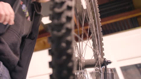 Man-Installing-Wheel-on-Bicycle-in-Garage