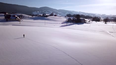 Joven-Camina-A-Través-De-Un-Gran-Campo-Nevado-En-Invierno-En-Suiza
