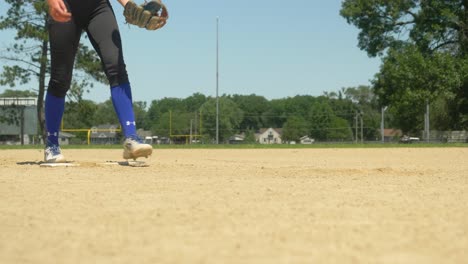 Práctica-De-Softball-De-Mujer,-Jugadora-Que-Deja-Caer-Y-Recoge-Béisbol,-Montículo-De-Lanzador-De-ángulo-Bajo,-Calcetines-Azules-Con-Tacos-Blancos