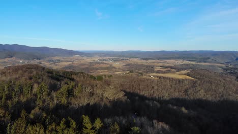 This-video-is-an-aerial-shot-flying-over-trees-toward-the-small-town-of-Hillsboro,-West-Virginia