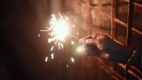 Hand-holding-firecrackers-at-night-celebrating-New-year,-Indian-festivals