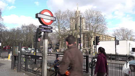 UK-February-2019---People-exit-and-enter-the-subway-to-Bethnal-Green-Underground-station-in-east-London-as-other-people-walk-past-on-the-pavement-and-traffic-drives-by-on-the-road