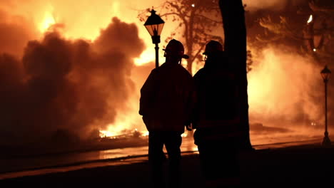 The-Silhouette-of-Two-Firemen-Watching-Huge-Flames-and-Plumes-of-Smoke-Pass-By-as-the-Historic-Shakespeare-Theatre-Burns-to-the-Ground-in-Stratford,-CT