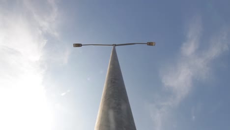 Street-light-pole-with-clouds-passing-overhead