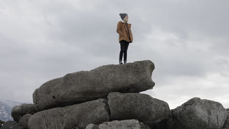 A-girl-stands-on-boulders-and-enjoys-the-view