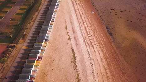 Drone-footage-of-Beach-with-beach-huts-directly-below
