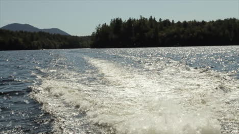 Dies-Ist-Eine-Aufnahme-Von-Wasser,-Das-Hinter-Einem-Boot-Hervorquillt,-Während-Es-Um-Den-Saranac-See-Fährt