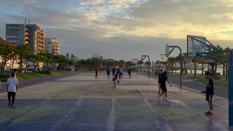 Adolescentes-Adolescentes-Jugando-Juegos-De-Baloncesto-En-Canchas-Al-Lado-Del-Océano