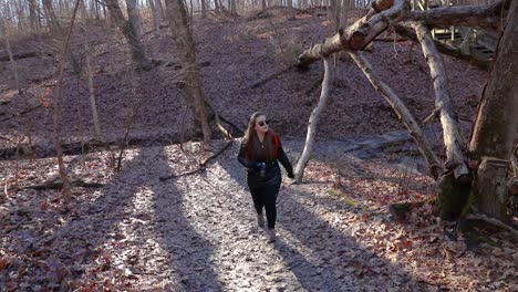 A-girl-photographer-is-exploring-a-forest-trail