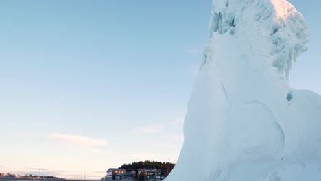 Tall-iceberg-inside-small-town-in-northern-sweden,-shot-from-below-on-a-tripod-during-sunsrice