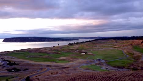 Aerial-overlooking-golf-course-with-evening-stormcouds-on-the-horizon
