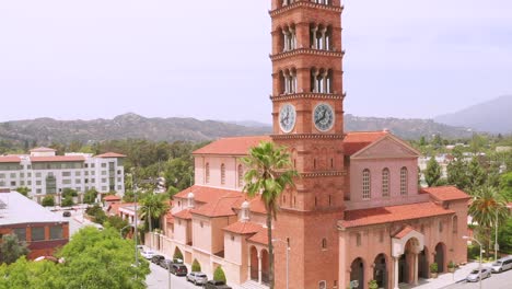 Rising-Drone-Aerial-footage,-of-St-Andrew-Catholic-Church-Clock-Bells-Tower-Landmark-of-Pasadena-City-California-With-Street-Traffic