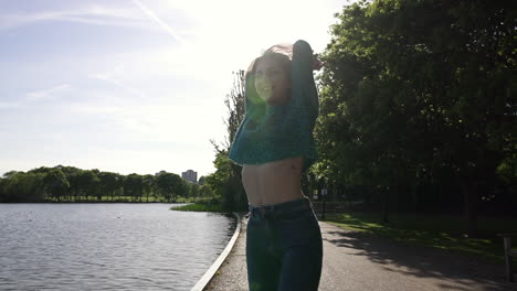 Beautiful-Italian-girl-walking-peacefully-and-spinning-in-a-tranquil-park-wearing-a-shimmery-sweater-in-London,-United-Kingdom