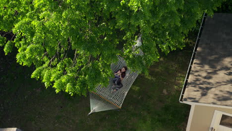 A-young-girl-relaxes-in-a-hammock-on-a-pretty-summer-day