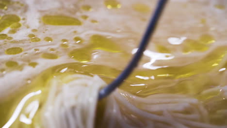 Close-up-of-a-chef-stirring-oil-into-a-pot-of-soup-in-slow-motion