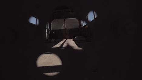 Peeping-through-the-hole-of-an-abandoned-bus-in-Atacama-desert,-South-America,-Chile