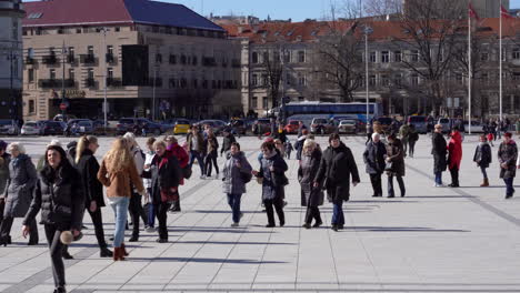 Un-Gran-Grupo-De-Personas-Camina-Sobre-Un-Pavimento-De-Piedra-En-Una-Plaza-Catheadral-De-Vilnius-Y-Disfruta-Del-Primer-Sol-De-Primavera