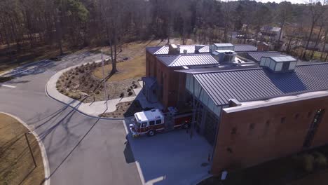 Aerial-of-a-firetruck-driving-out-of-a-fire-station-garage-on-its-way-to-an-emergency