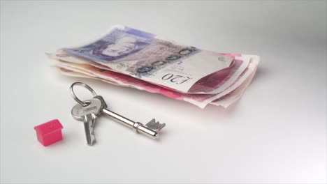 A-Black-male-counting-pound-notes-with-a-red-house-and-a-pair-of-keys