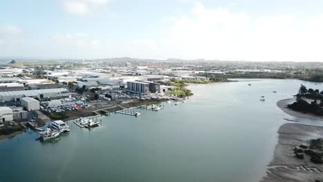 aerial-4K,-flying-forward-slowly,-view-of-Auckland-suburbs-and-boat-factory-on-coastline