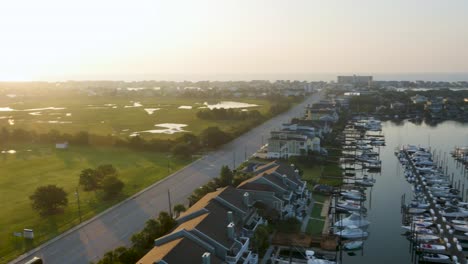 4k-rotating-view-of-marina-to-reveal-park-with-green-grass-near-the-ocean-at-sunrise
