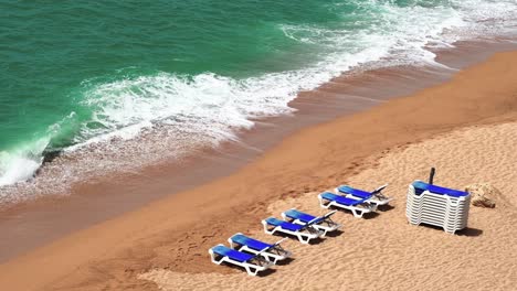 Aerial-view-of-some-beach-loungers-with-rough-sea