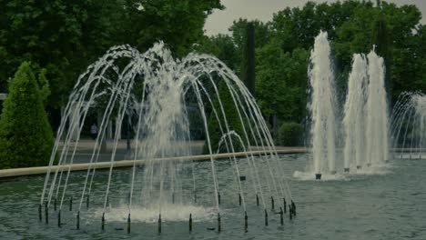 Eine-Aufnahme-Eines-Springbrunnens-Mit-Mehreren-Wasserstrahlen-In-Einem-Teich