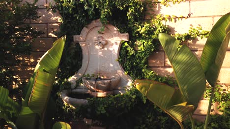 Pan-shot-of-water-fountain,-in-a-backyard,-in-Los-Angeles,-California,-USA