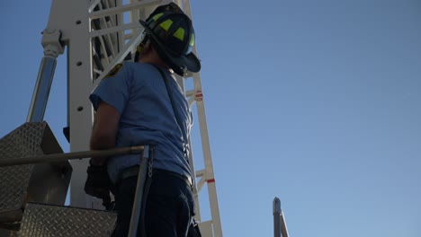 Firefighter-tests-a-long-extension-ladder-on-a-fire-truck-used-for-emergency-response-and-firefighting