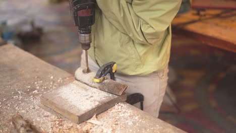 Carpenter-working-drilling-a-hole-with-woodworking-machines-in-carpentry-shop