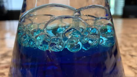 Ein-Ozean-in-einer-Flasche-Wissenschaftsexperiment-Für-Kinder,-Das-Babyöl,-Wasser-Und-Blaue-Lebensmittelfarbe-Mischt