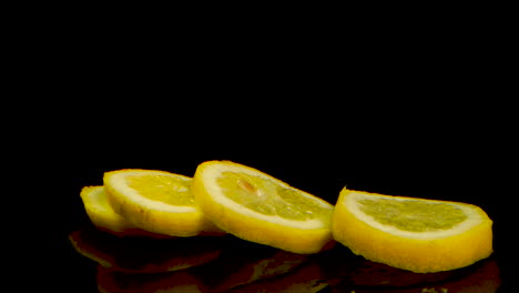 Gelbe-Zitrone-Fällt-Und-Trennt-Sich-Auf-Einem-Schwarzen-Tisch-In-Scheiben