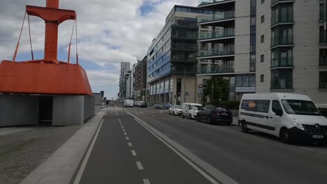 Cycling-in-Dublin-Docklands-with-buildings-on-the-right-hand-side,-smooth-footage