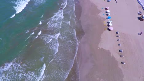 Bird´s-eye-view-of-the-coastline-Boca-del-Rio-beach,-image-from-the-heights-of-how-the-beach-looks,-with-serene-waves-and-white-sand,-the-umbrellas-accompany-the-coming-and-going-of-the-sea