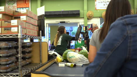 Cashier-at-Sprouts-Farmer's-Market-taking-care-of-customers-in-line